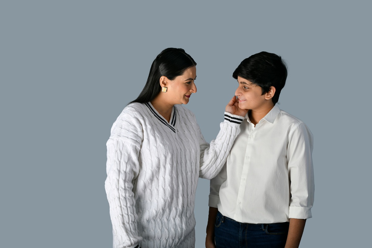 A woman speaking gently with a young student, offering one-to-one support.